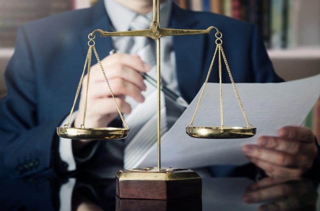 lawyer reading a paper in front of a scale